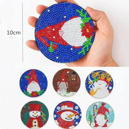 Hand houdt ronde diamond painting kerstman met rode muts op een blauwe achtergrond, 10 cm groot.