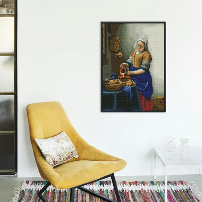 Diamond painting van het Melkmeisje aan de muur naast een gele fauteuil en een kleurrijk tapijt.