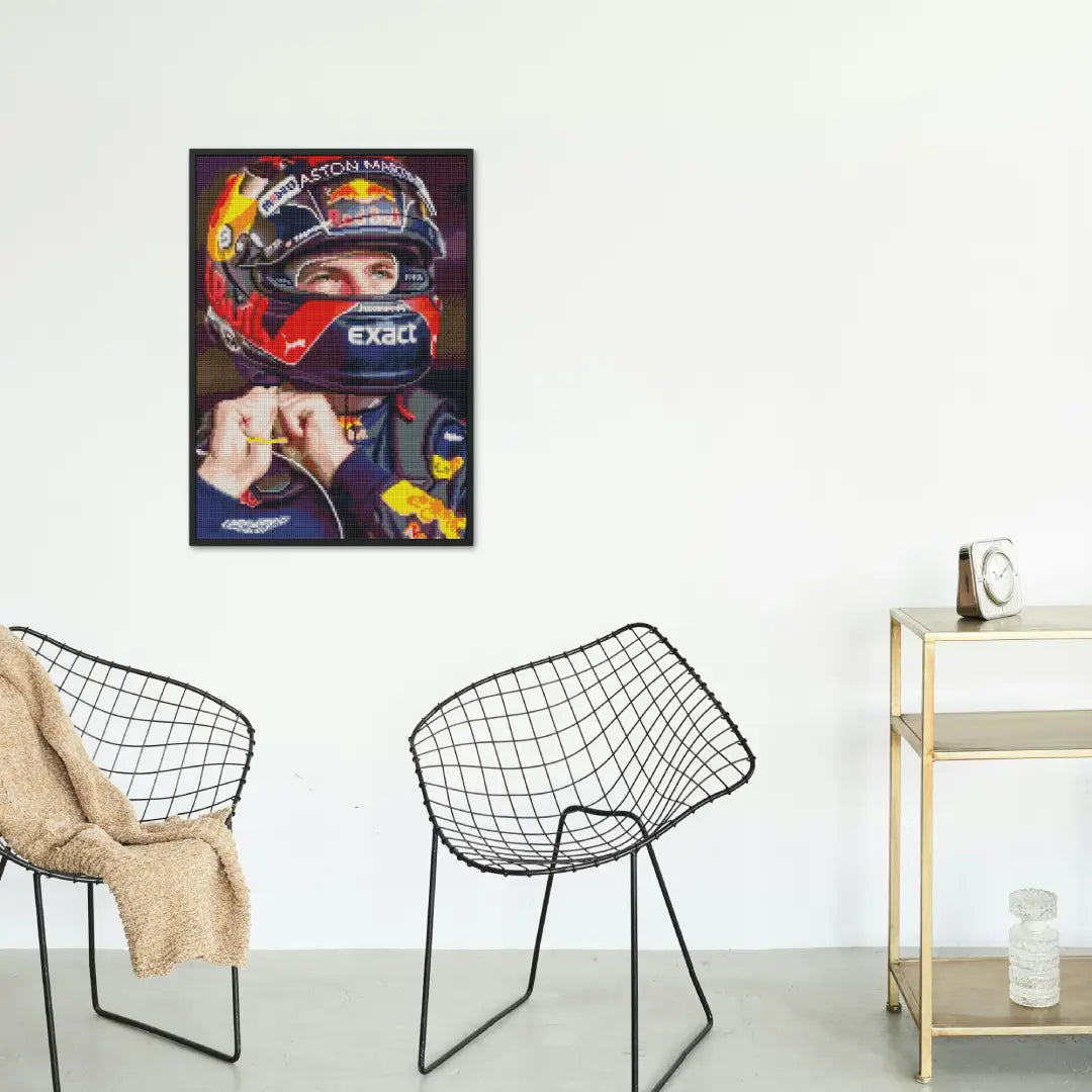 Diamond painting van Formule 1-coureur Max Verstappen met helm in een interieur, opgehangen aan de muur.