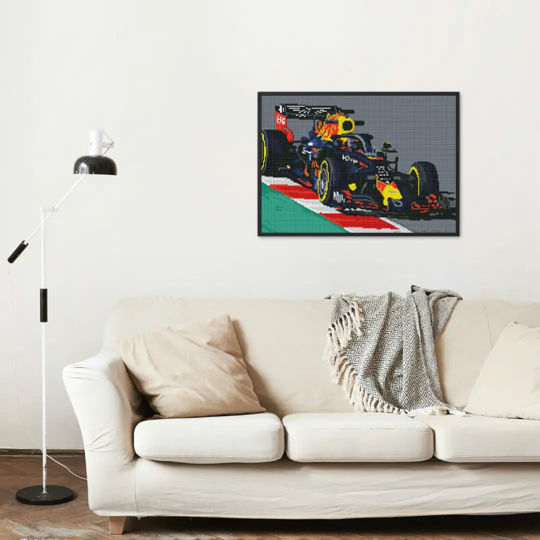 Diamond painting van een Formule 1-raceauto in een interieur, opgehangen boven een bank als decoratie.